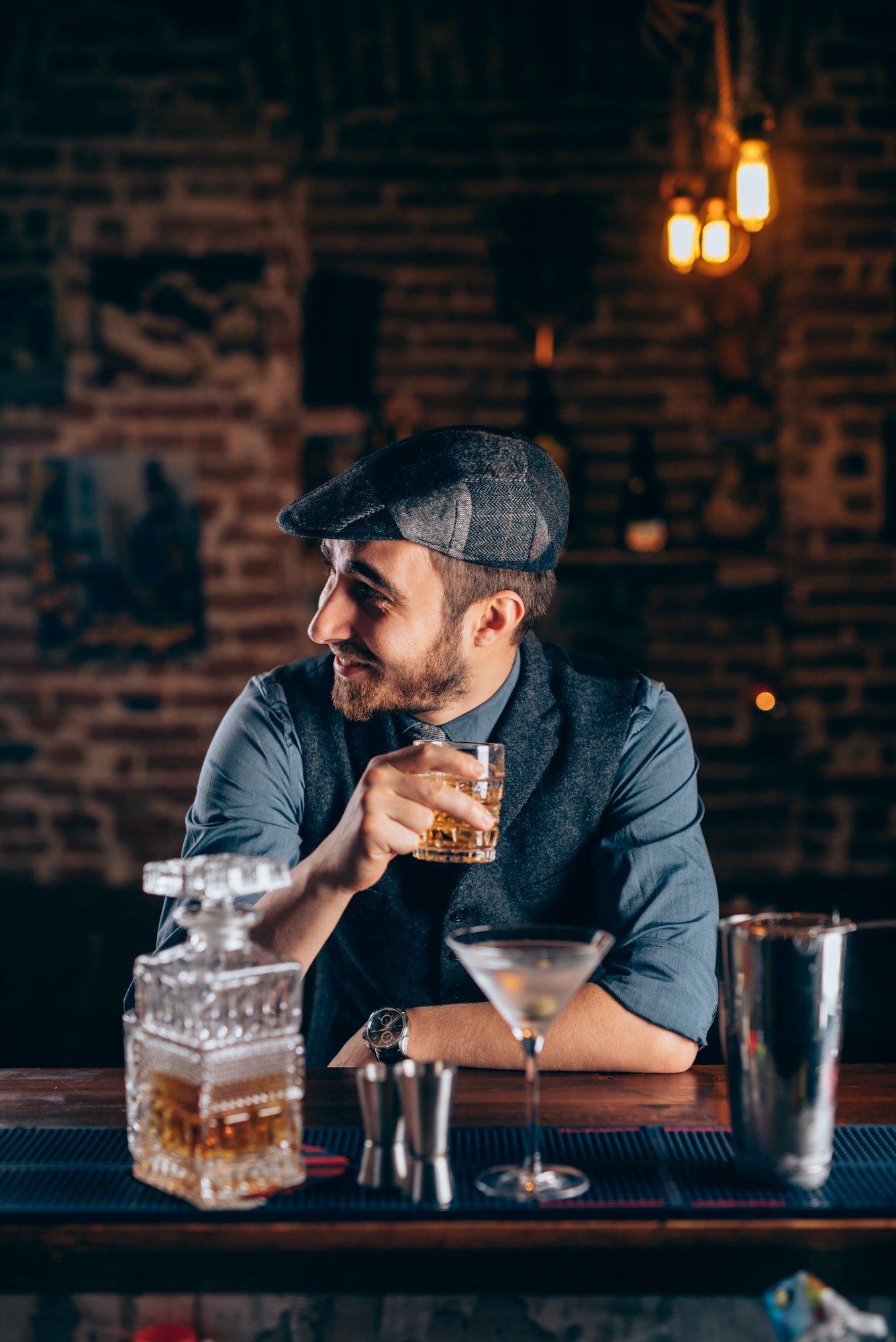 cheerful-bartender-enjoying-an-alcoholic-drink-at-pub-bar-or-restaurant-evening-relaxation-concept.jpg